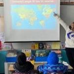 两名实习教师站在小学生面前看世界地图